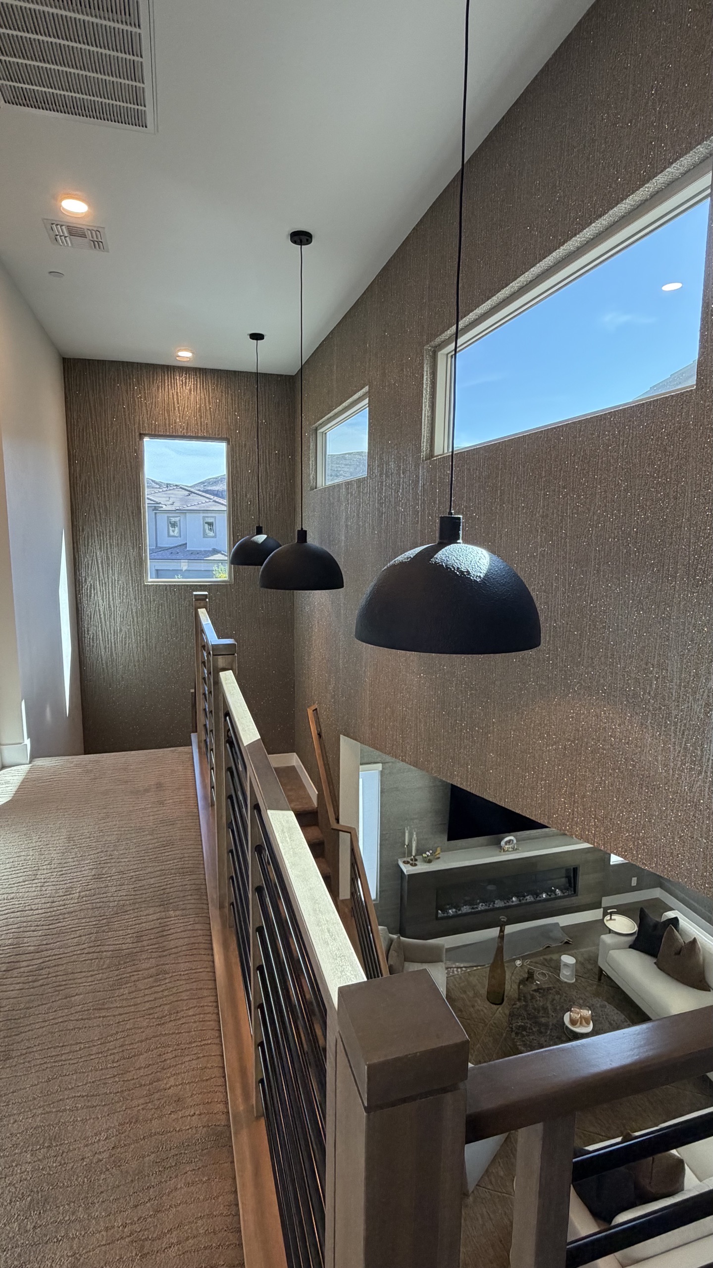 Hallway and loft with bronze textured wallcovering and pendant lights