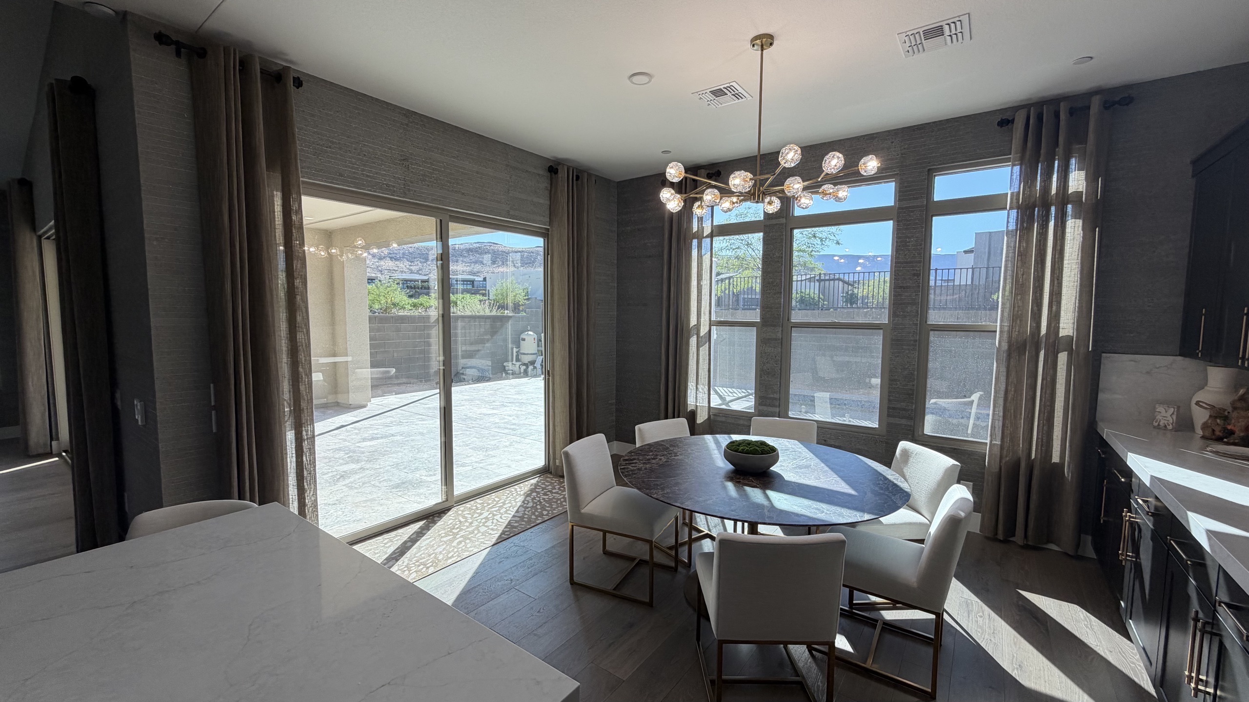Dining room with grey grasscloth wallcovering and custom drapery panels